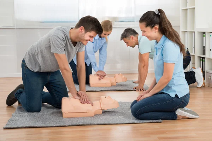 Participants practicing CPR on manikins during a class.